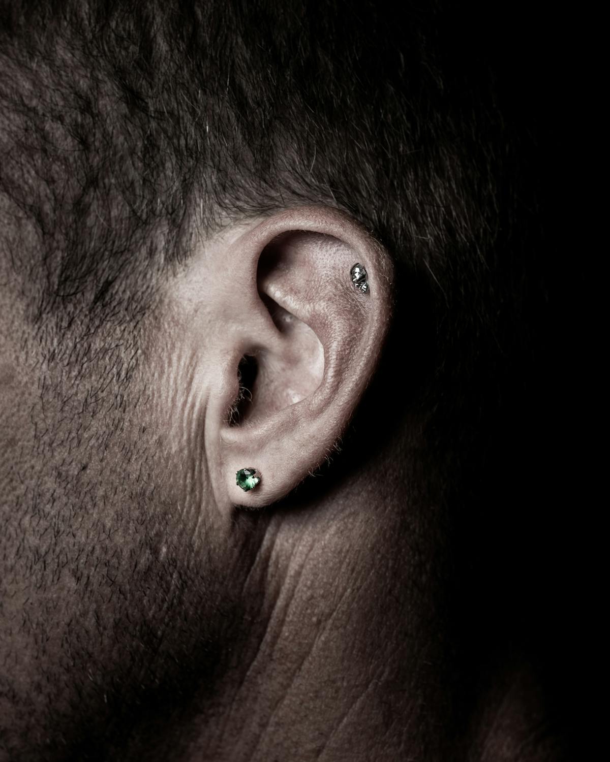 Gros plan sur oreille avec plusieurs piercings