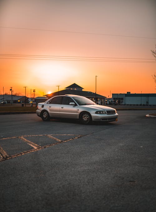 A Silver Sedan Car Parked on the Road during Sunset