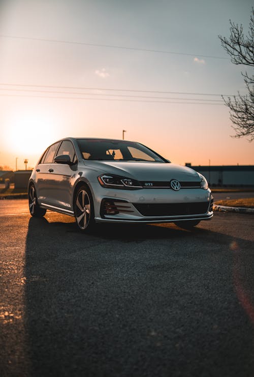 A Silver Sedan Car Parked on the Road during Sunset