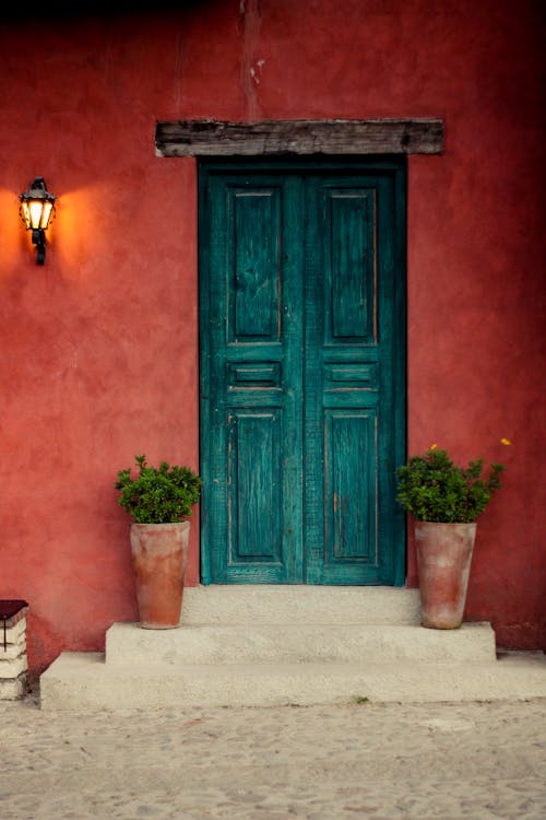 Green Wooden Door on Red Concrete Wall