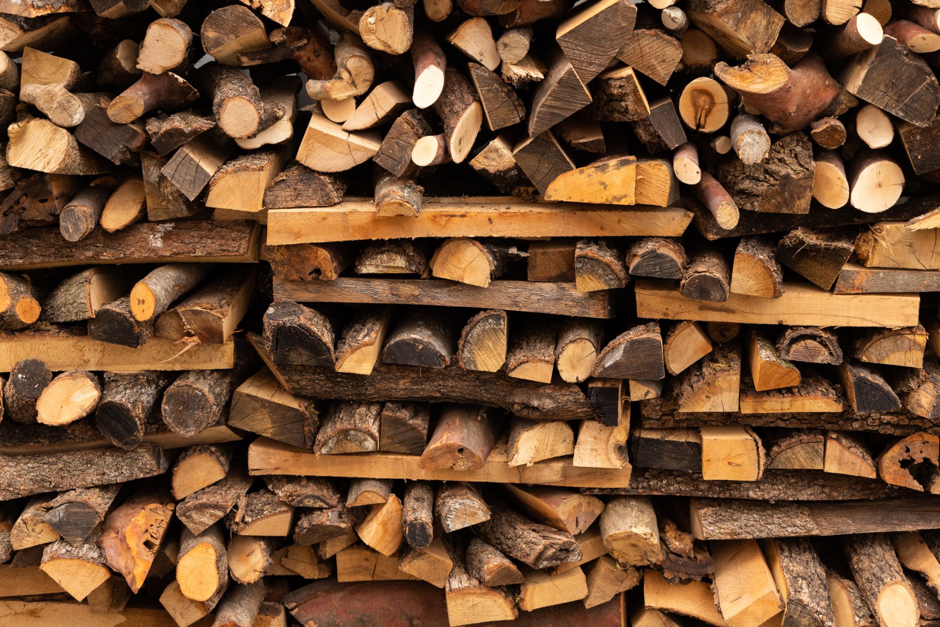 A close-up of neatly stacked firewood logs, perfect for outdoor heating or rustic decor.