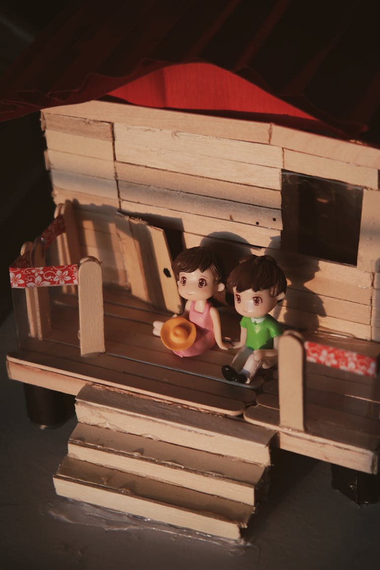 Couple Figurines On Wooden Toy House