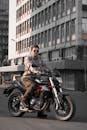 Man In Sunglasses Riding a Motorbike Near Buildings