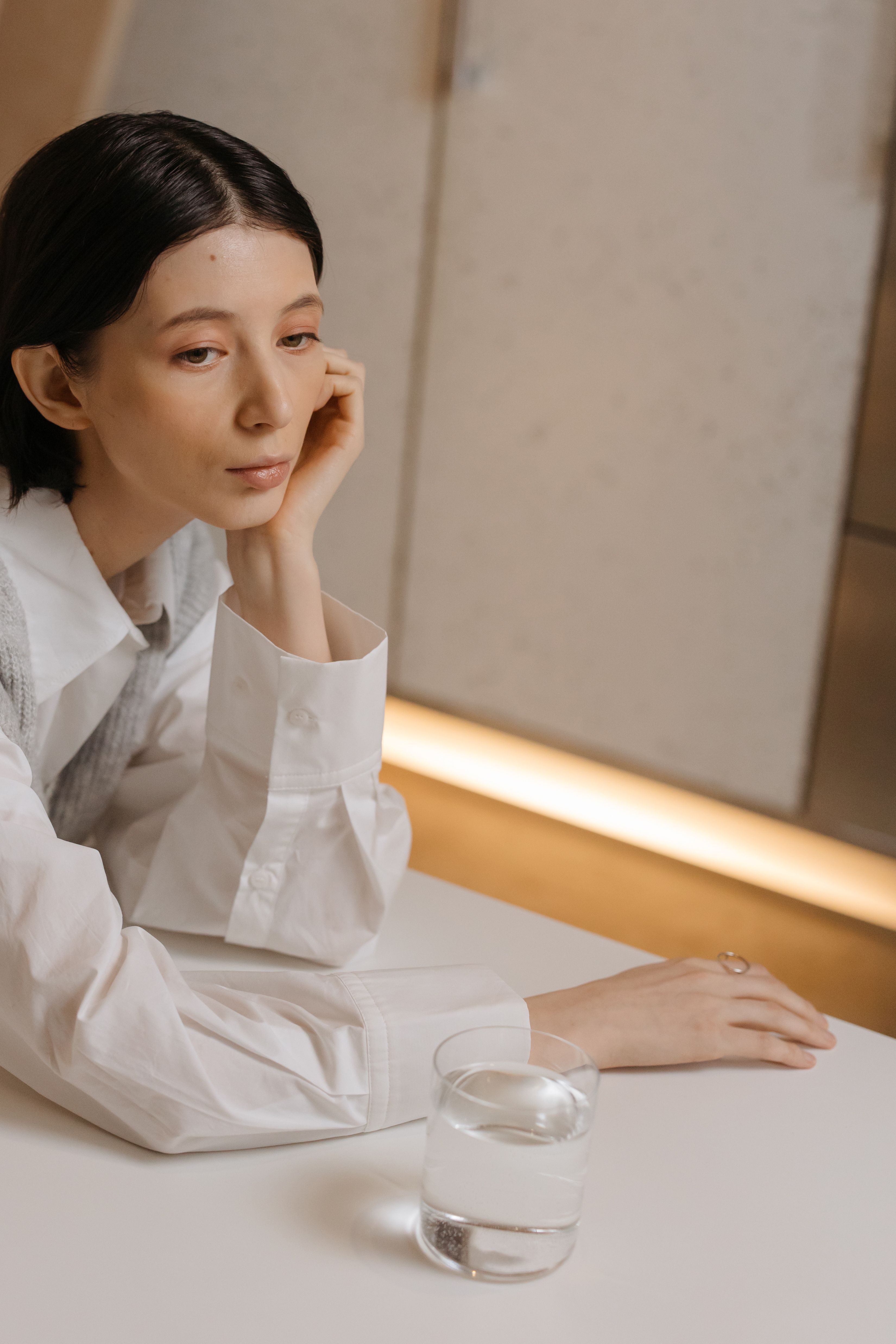 Woman in White Long Sleeve Shirt Sitting by the Table · Free Stock Photo