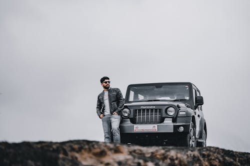 Man Standing in Front of a Black Vehicle