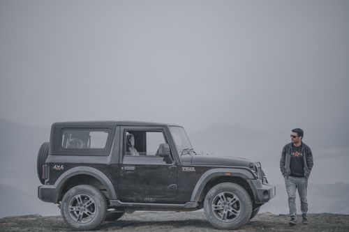 Free Man with 4x4 off-road jeep in foggy mountains of India, capturing the spirit of adventure and exploration. Stock Photo