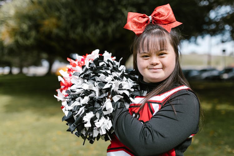 A Woman In Cheerleader Outfit Holding Pompoms