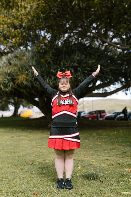 Woman in Cheerleader Outfit Standing on Grass
