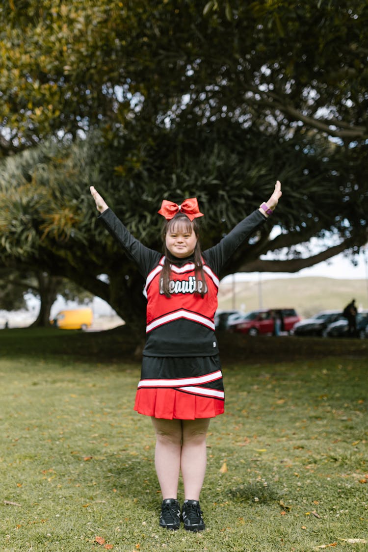 Woman In Cheerleader Outfit Standing On Grass