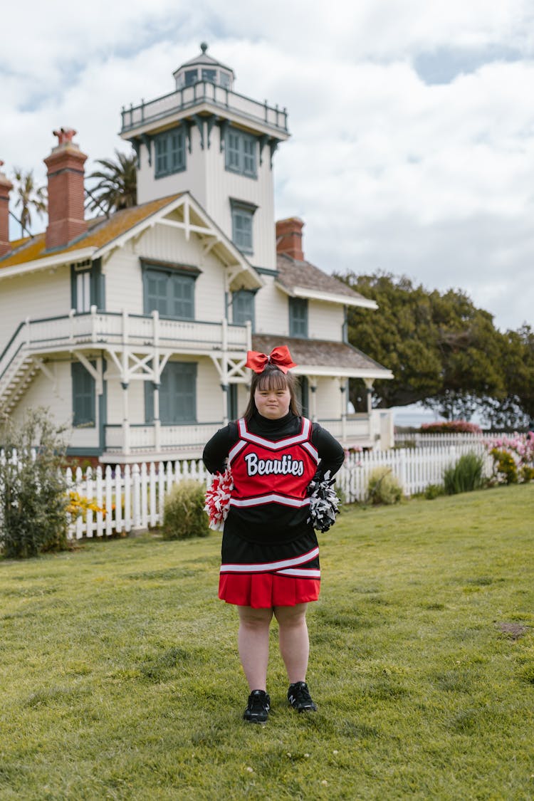 A Woman In Cheerleader Outfit Standing Outside 