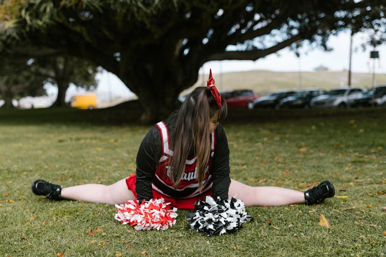 A Woman In Cheerleader Outfit Doing Splits