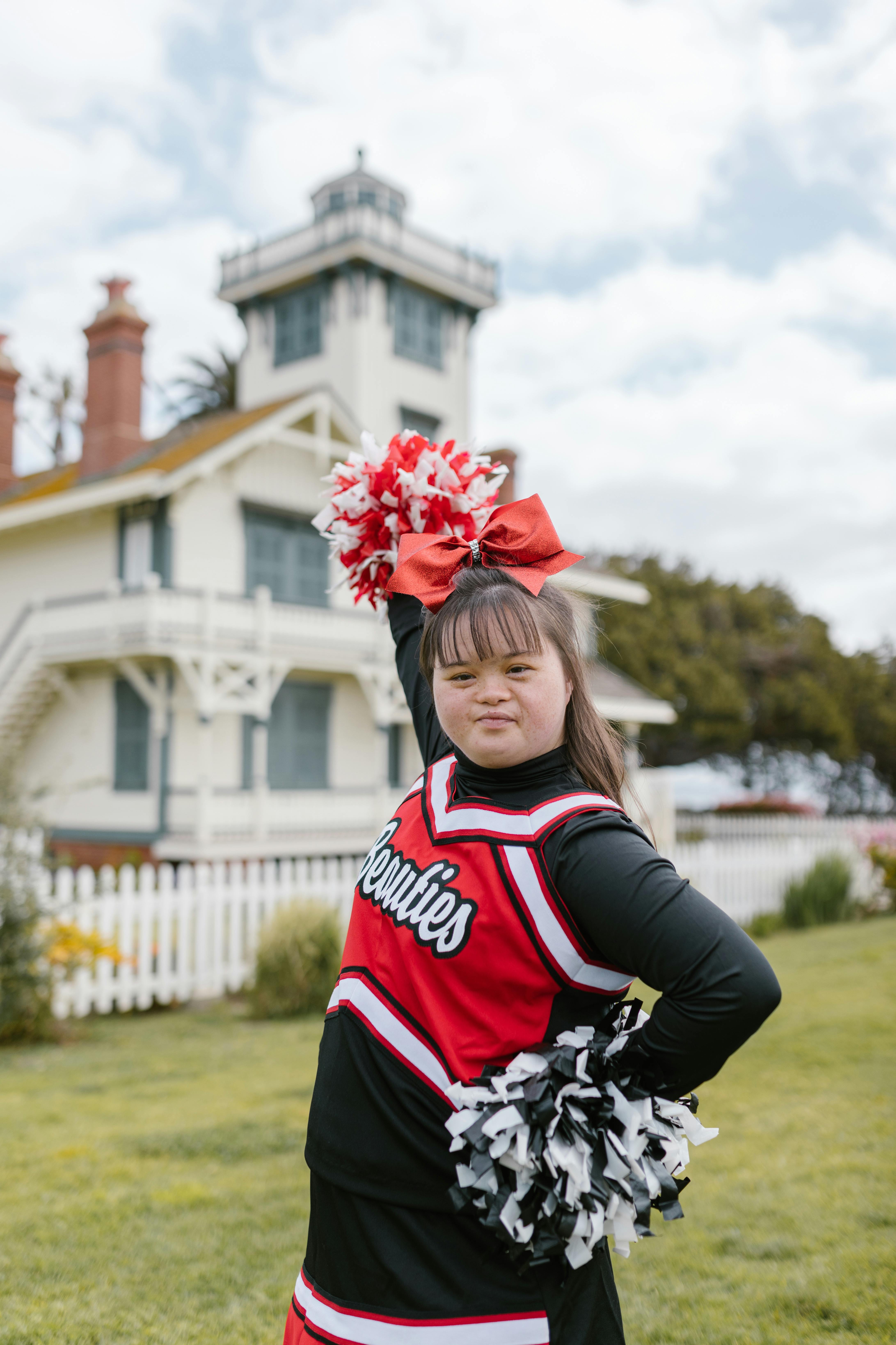 girl in a cheerleader costume with a pom poms on a white Stock