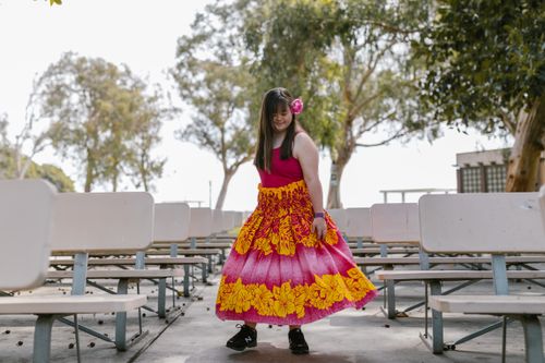 Free Young girl wearing a colorful dress with floral patterns in an outdoor park setting, enjoying a carefree moment. Stock Photo