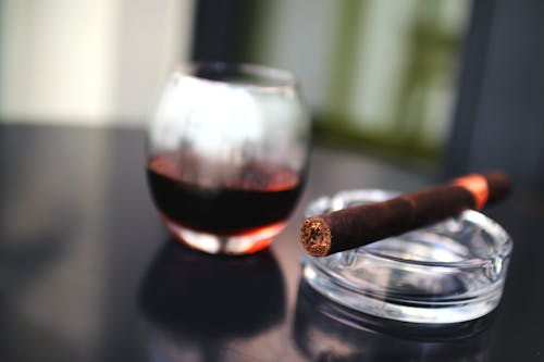 무료 술잔 옆에있는 갈색 담배 스톡 사진