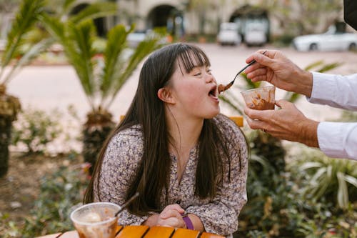 Person Feeding a Woman Ice Cream