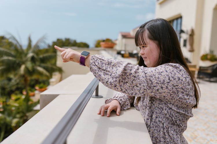 A Girl In Floral Top Pointing Her Finger