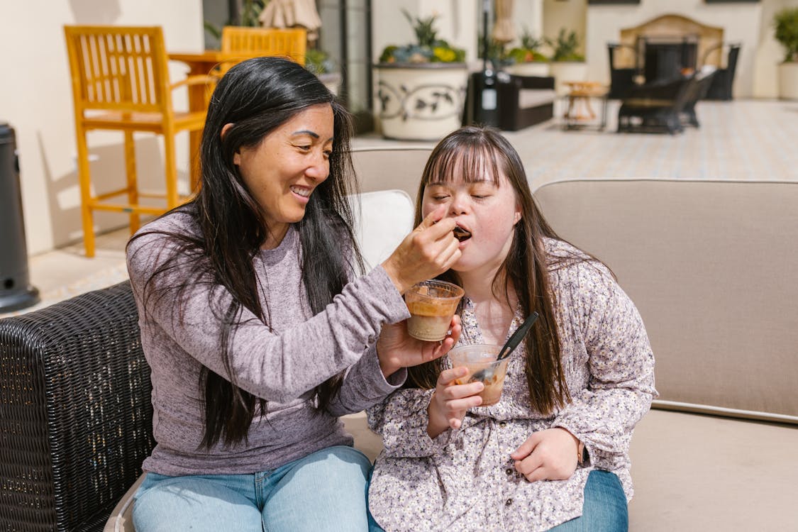 A Mother Feeding Pudding to Her Daughter