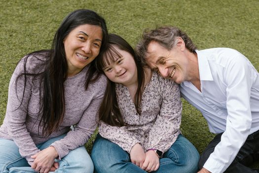 A loving family spends quality time together, embracing happiness and togetherness outdoors.