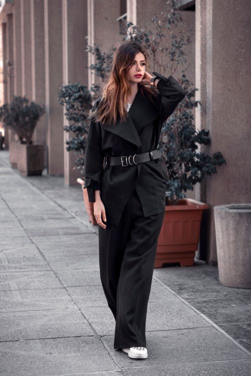 Free Trendy woman in black outfit posing stylishly on urban street, embodying modern street fashion. Stock Photo