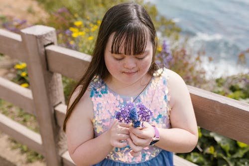 A Girl Holding Purple Flowers