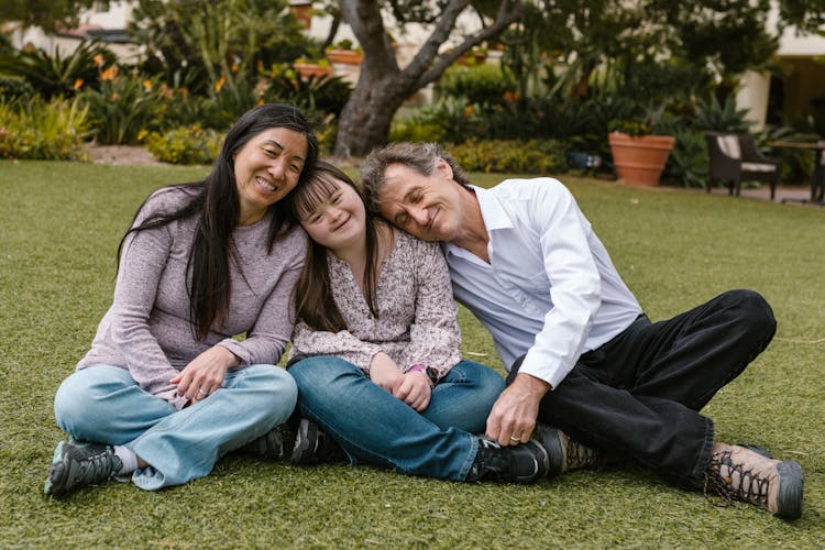 A Happy Family Sitting On The Grass