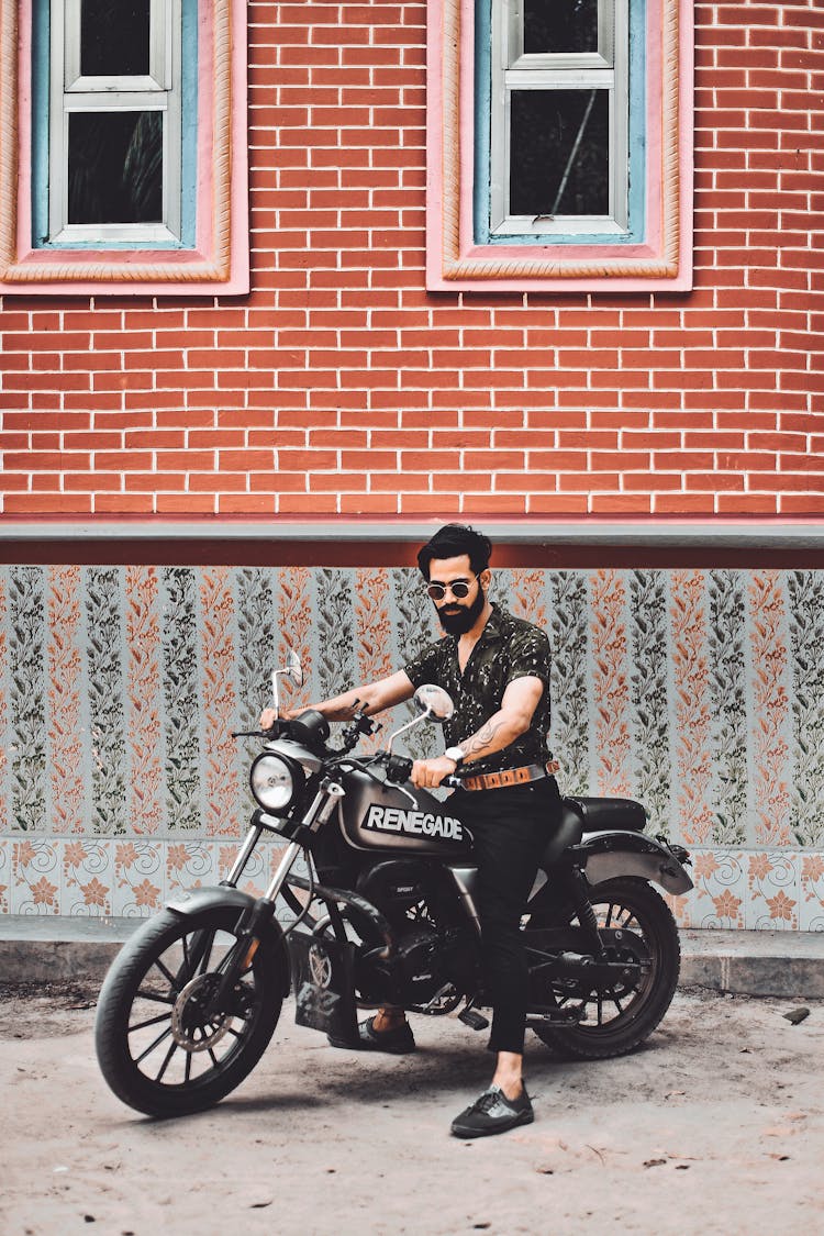 A Bearded Man Riding A Motorcycle