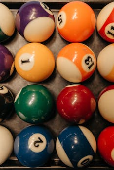 Vibrant billiard balls neatly arranged in grid pattern for a striking visual display.