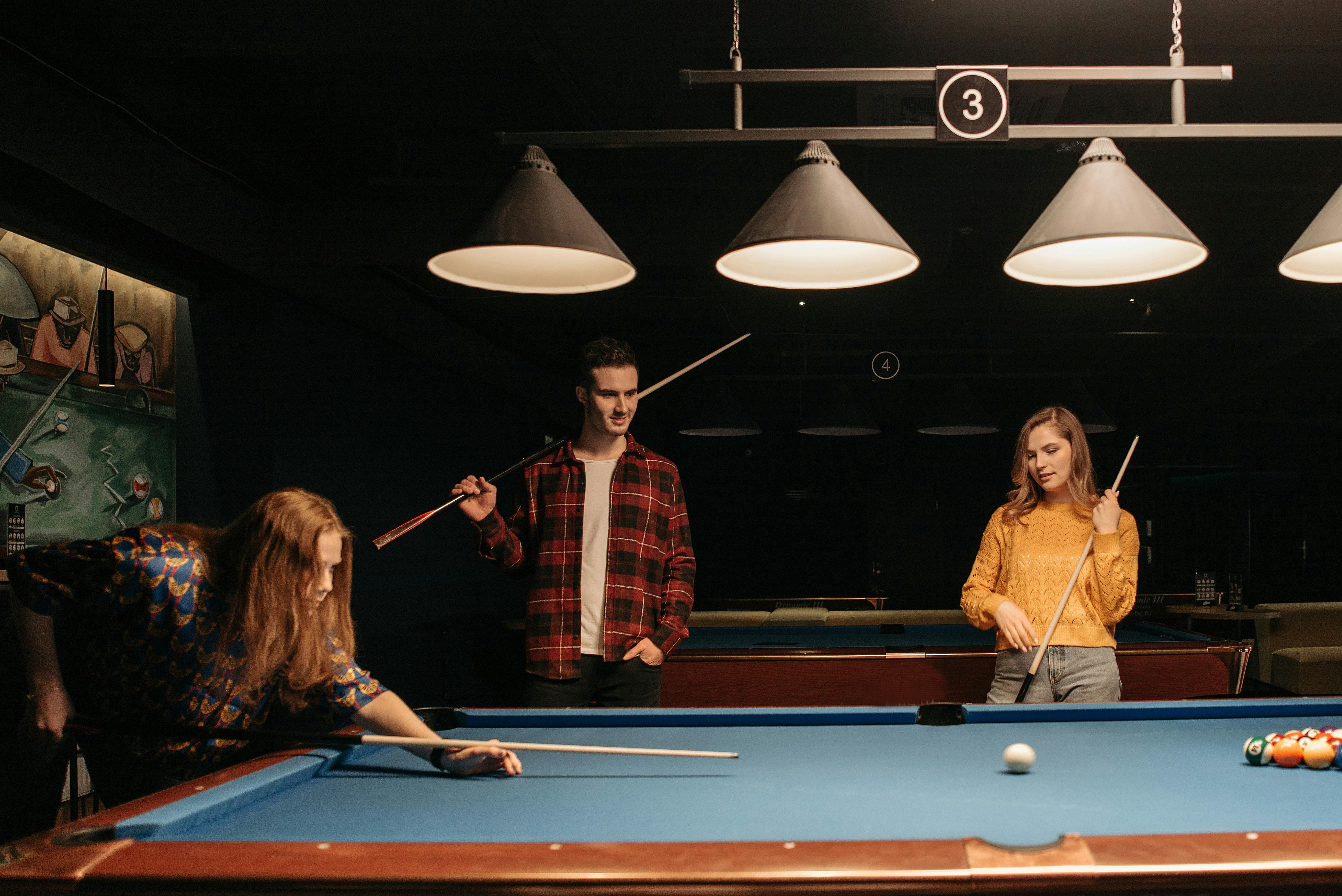 Premium Photo  Friends playing pool at billiard club and shooting