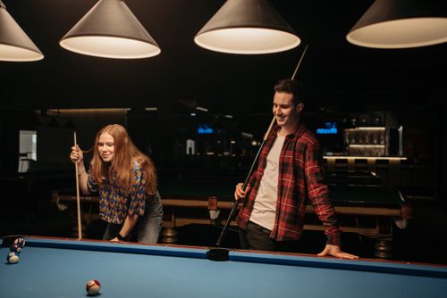 Free Two friends playing pool in a cozy indoor setting, enjoying a fun night out. Stock Photo