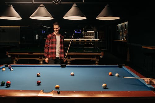 Free A Man in Checkered Plaid Shirt Holding a Cue Stick  Stock Photo