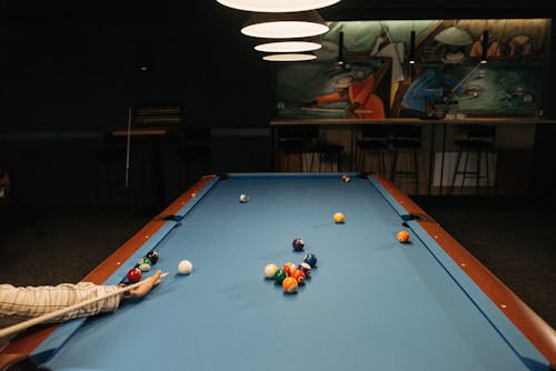 A Person Holding a Cue Stick on a Pool Table 