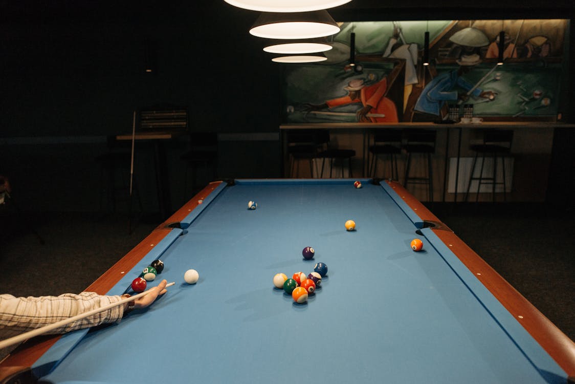 Free A Person Holding a Cue Stick on a Pool Table  Stock Photo