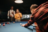 Man in Red and Black Jacket Playing Billiard