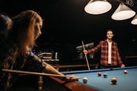 Woman in Red and Black Plaid Dress Shirt Playing Billiard