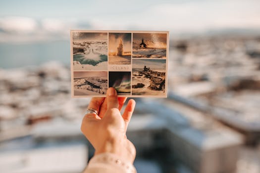 A hand holding an Iceland postcard with scenic images against a blurred outdoor background.