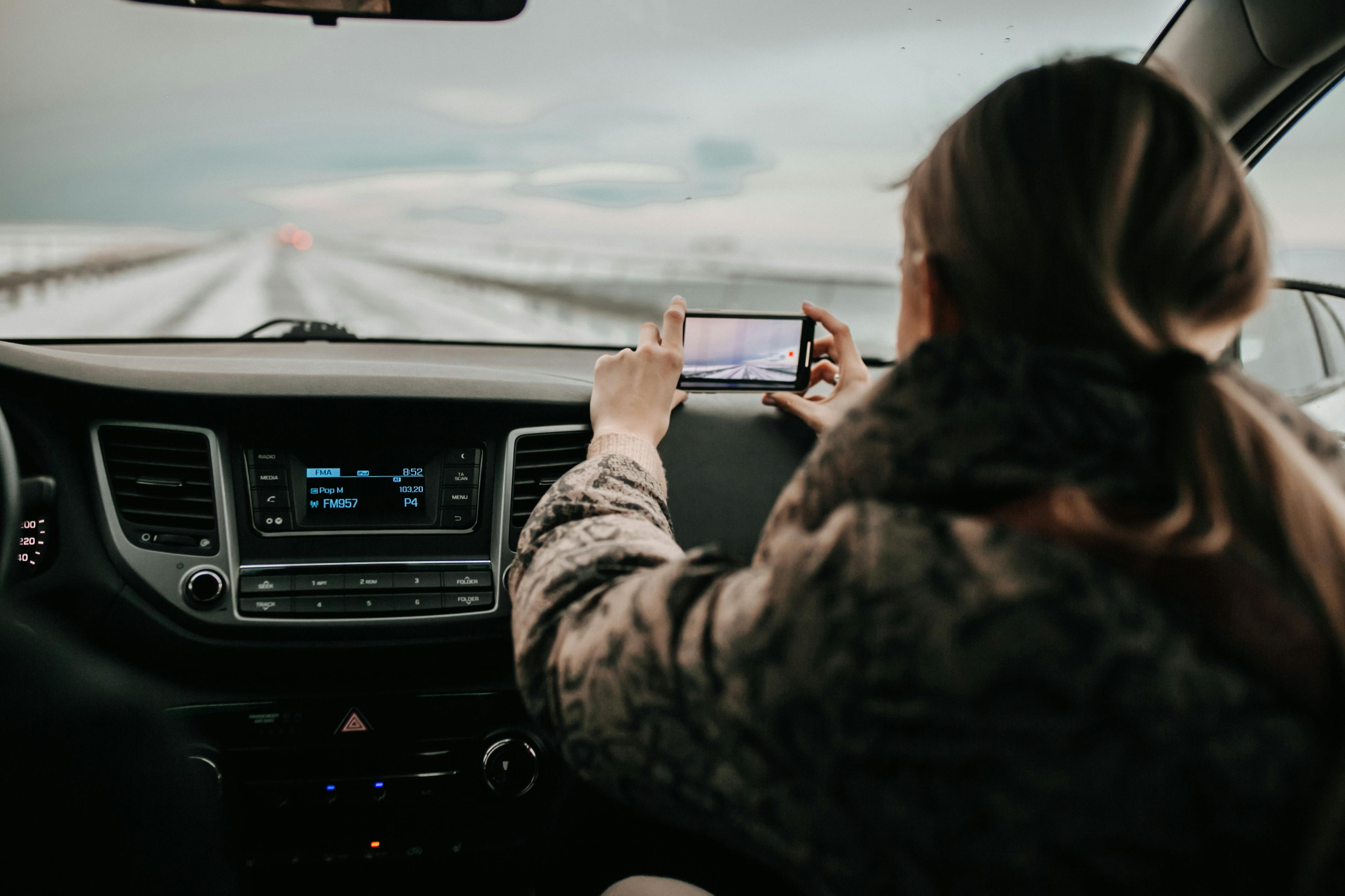 back view of a woman inside a car taking picture