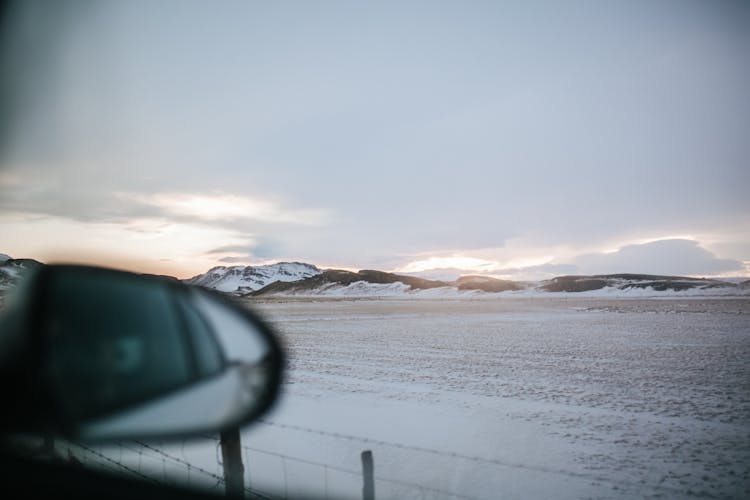 A Snow Covered Field And Mountains