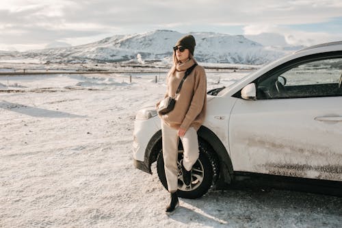 Free A Stylish Woman Leaning on a Car Stock Photo