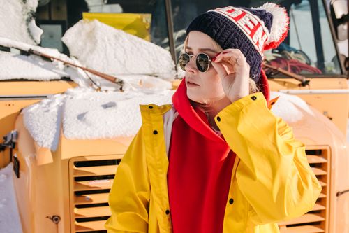 Free A fashionable woman in winter attire in front of a snow-covered bus, enjoying the cold weather. Stock Photo
