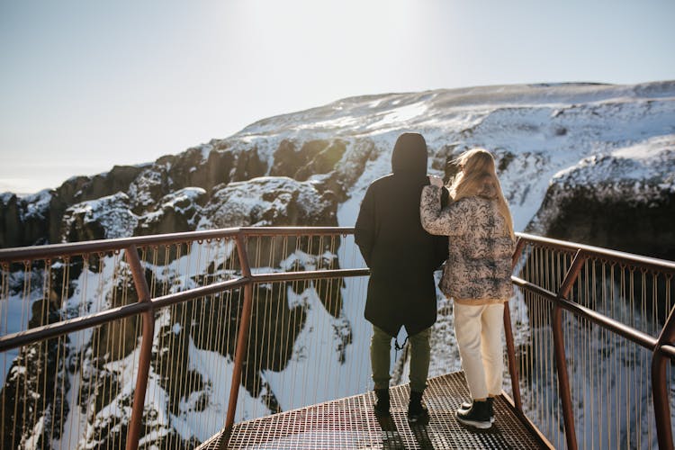 Back View Of A Couple On The Mountain Viewing Deck