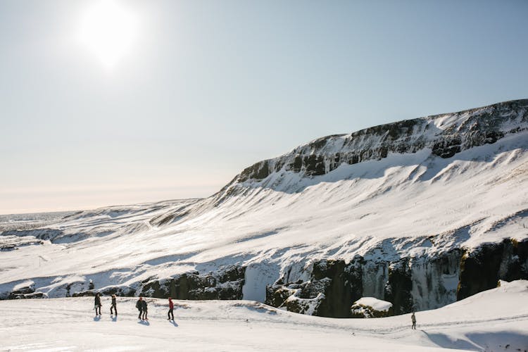 People Walking On A Snow Covered Mountain Trail