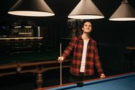 Man Holding a Cue Stick Near a Billiard Table