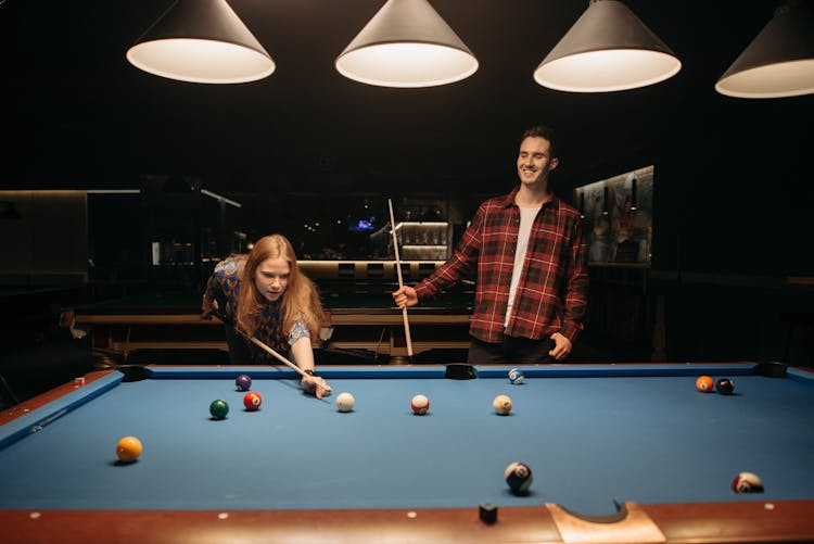 A Man And A Woman Playing Billiards 