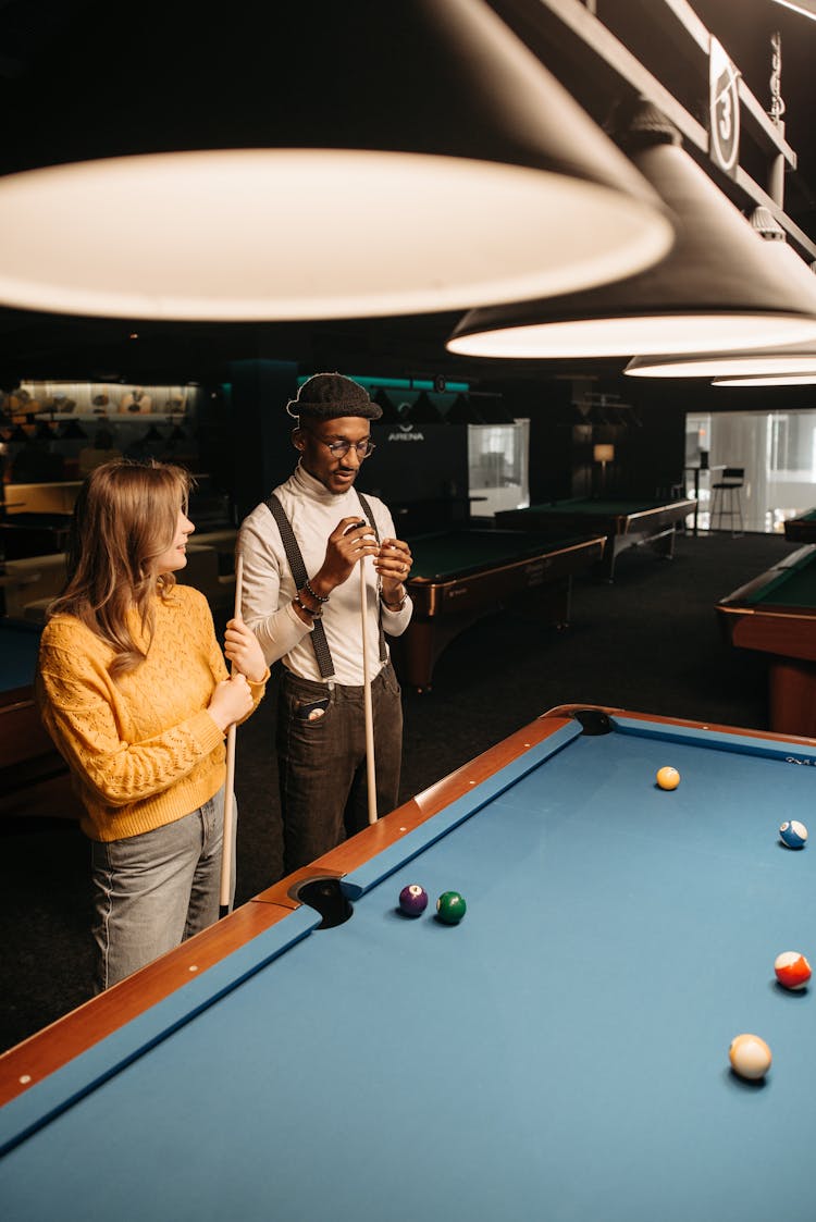 A Man Putting Chalk On A Cue Stick