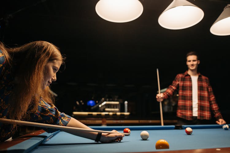 A Man And A Woman Playing Billiards