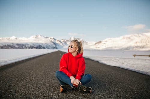 Free A Stylish Woman Sitting on the Road and Posing Stock Photo