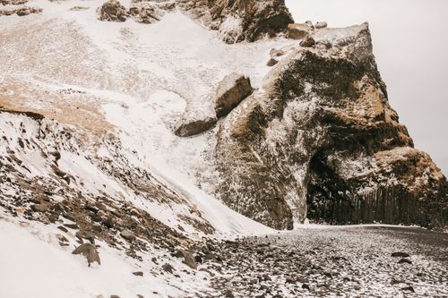 Free A striking view of a snow-covered mountain and rocky terrain in a winter landscape. Stock Photo