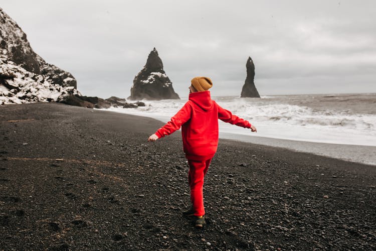 Girl In Red Sweatsuit Walking On Seashore