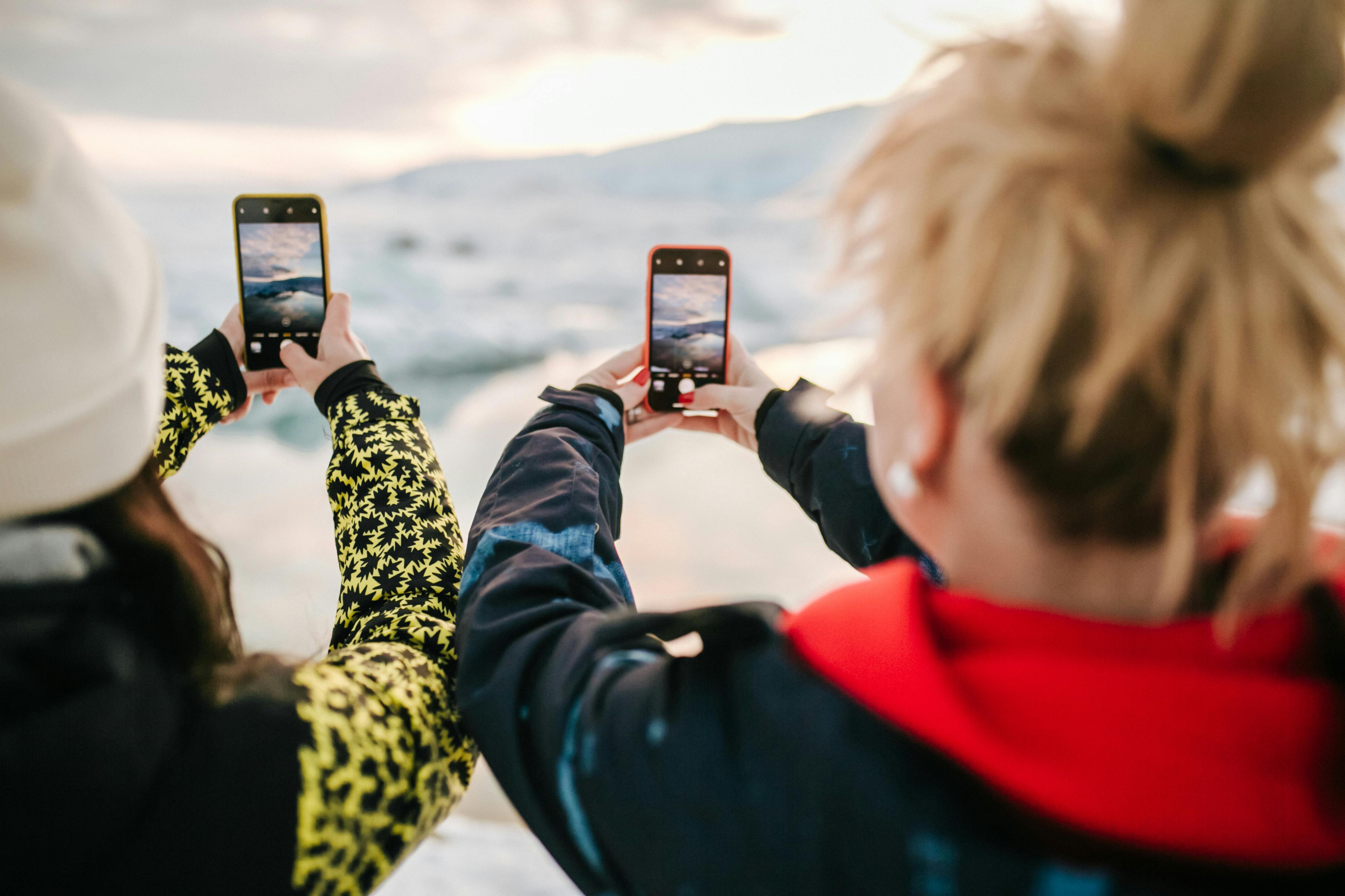 back view of two people taking photo using their cellphones