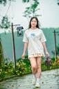 Pretty Girl in White Shirt Walking on the Pathway while Carrying Her Handbag